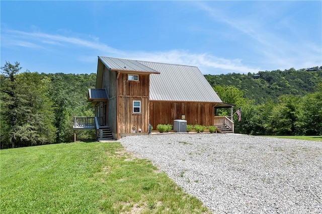 exterior space featuring central AC unit and a lawn