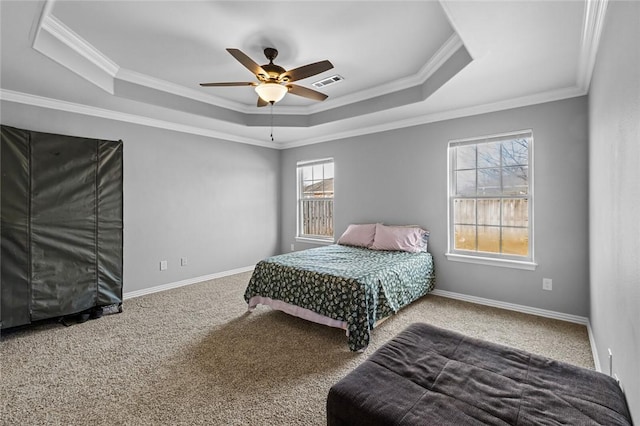 carpeted bedroom with crown molding, a tray ceiling, and ceiling fan