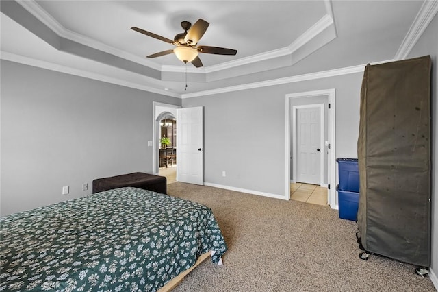 bedroom with crown molding, ceiling fan, a tray ceiling, and light colored carpet