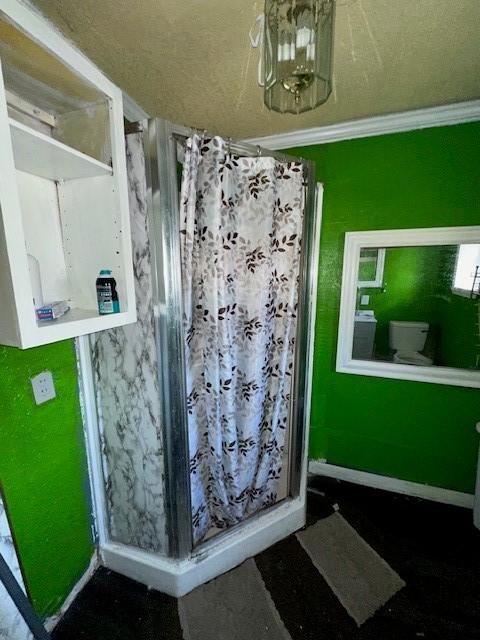 bathroom with an inviting chandelier, ornamental molding, and toilet