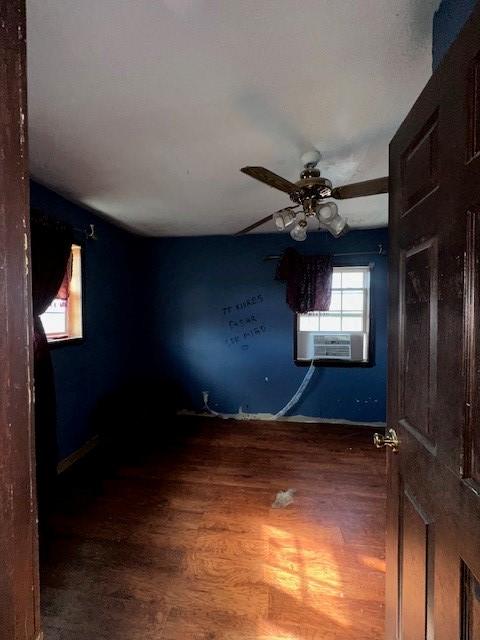 unfurnished room with hardwood / wood-style flooring, ceiling fan, and cooling unit