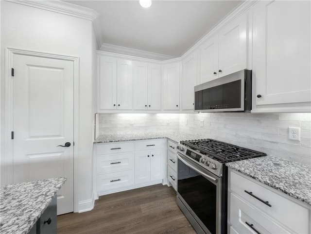 kitchen with appliances with stainless steel finishes, white cabinetry, tasteful backsplash, light stone countertops, and dark hardwood / wood-style flooring