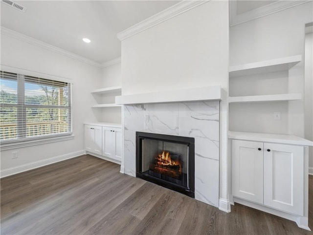 unfurnished living room featuring crown molding, dark hardwood / wood-style floors, and a premium fireplace