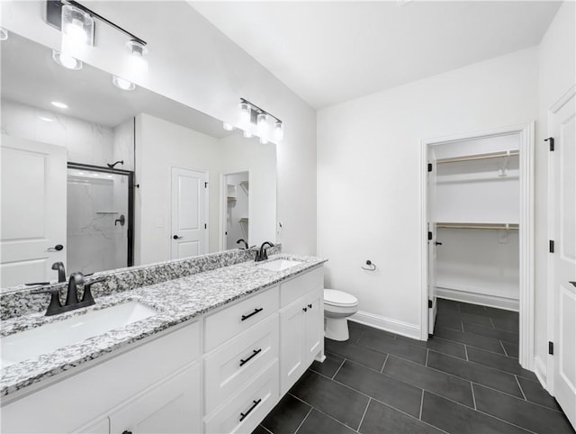 bathroom with vanity, toilet, and a shower with shower door