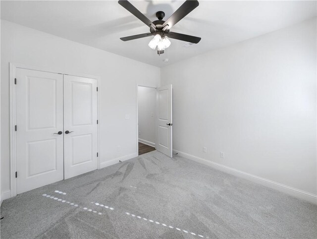 unfurnished bedroom with a closet, ceiling fan, and carpet flooring