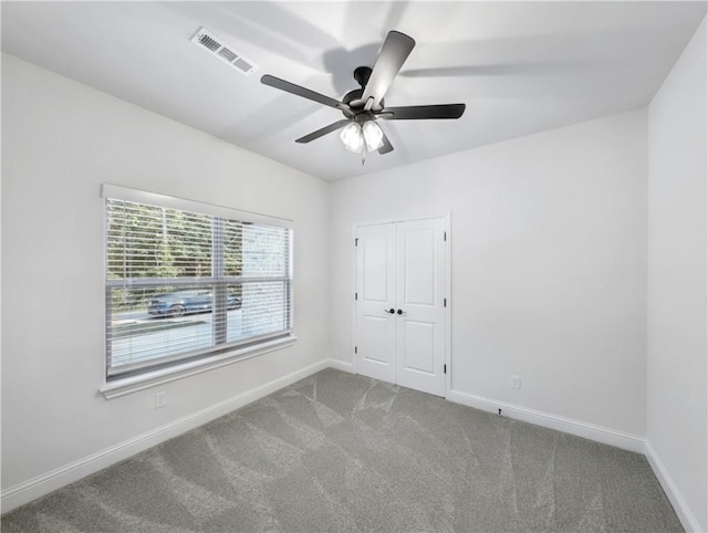 carpeted spare room featuring ceiling fan