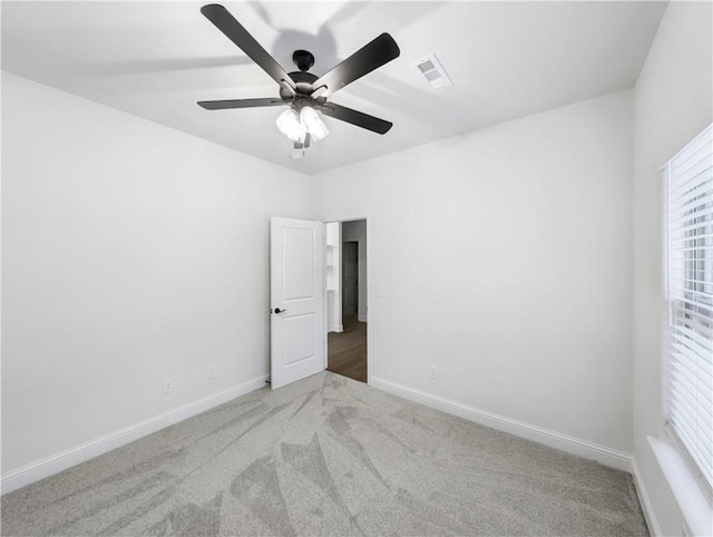 unfurnished room with ceiling fan and light carpet