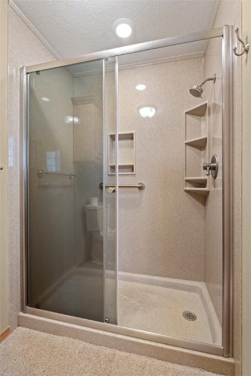 bathroom with an enclosed shower and a textured ceiling