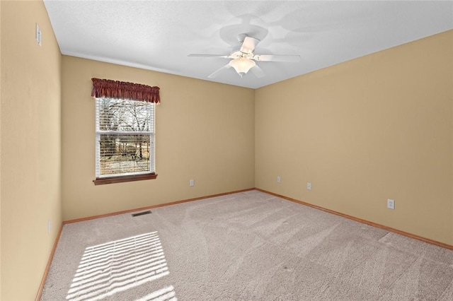 spare room with ceiling fan and carpet