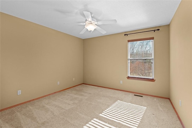 carpeted spare room featuring ceiling fan