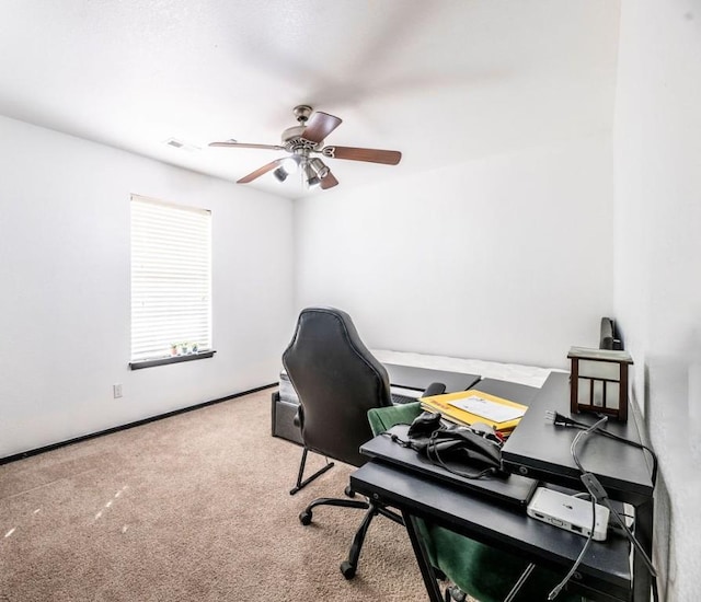 carpeted home office featuring ceiling fan