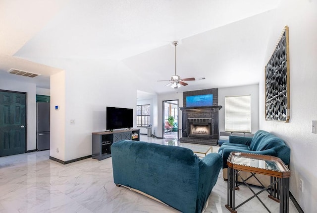 living room featuring ceiling fan, a fireplace, and vaulted ceiling