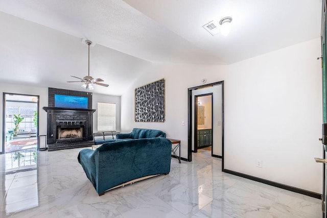 living room featuring ceiling fan, a fireplace, and vaulted ceiling