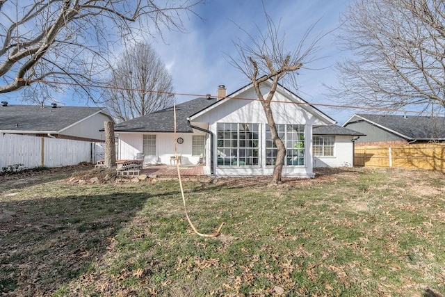 back of house with a sunroom and a lawn