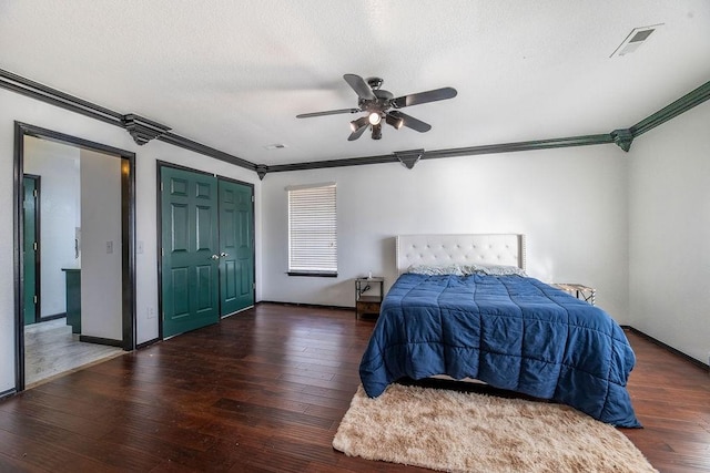 bedroom featuring crown molding, a textured ceiling, dark hardwood / wood-style floors, and ceiling fan