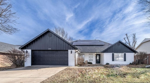 view of front of property featuring a garage and solar panels