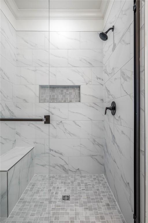 bathroom featuring a stall shower and crown molding