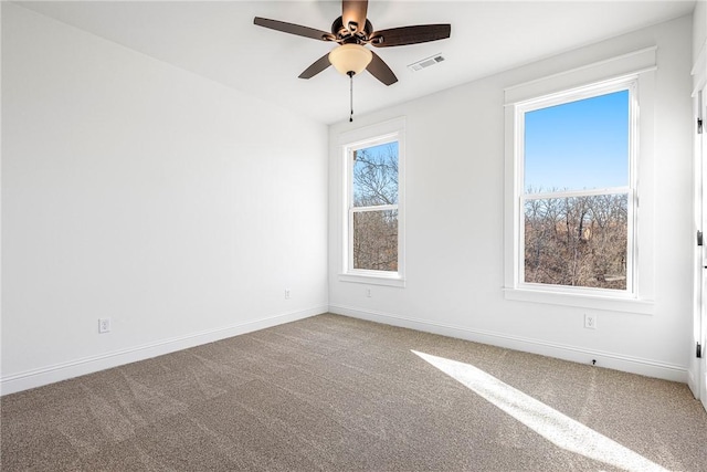 carpeted empty room featuring baseboards, plenty of natural light, visible vents, and ceiling fan