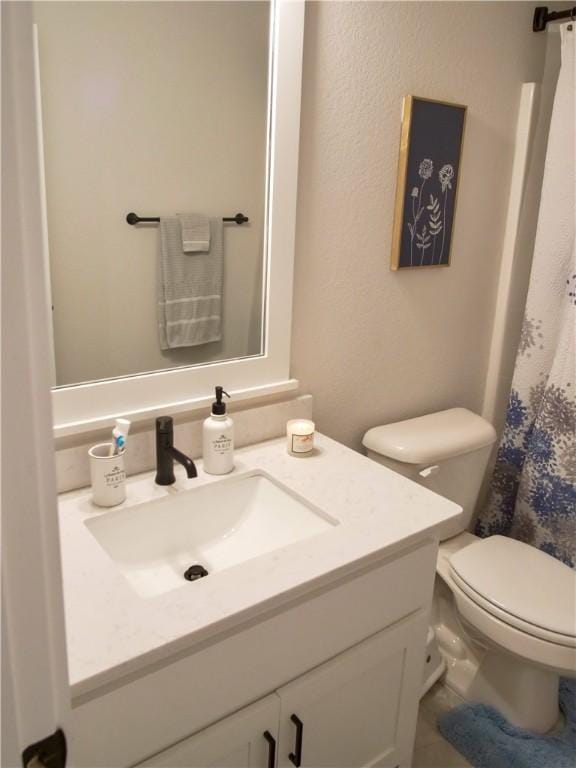 bathroom with vanity, a shower with shower curtain, and toilet