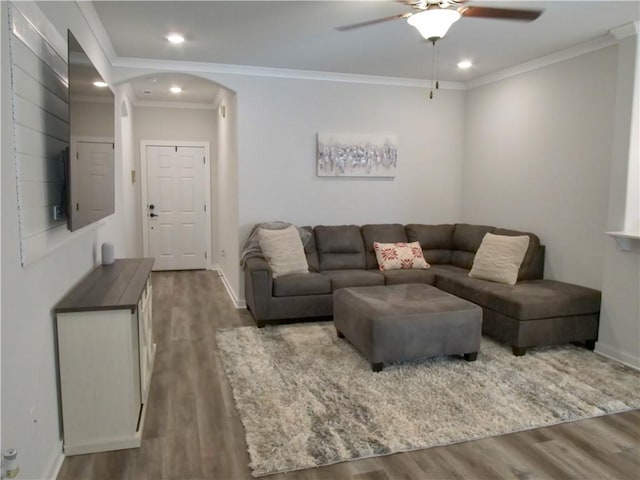 living room with hardwood / wood-style flooring, ornamental molding, and ceiling fan