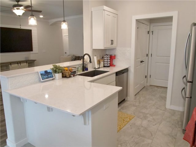 kitchen featuring pendant lighting, a kitchen bar, stainless steel appliances, and kitchen peninsula