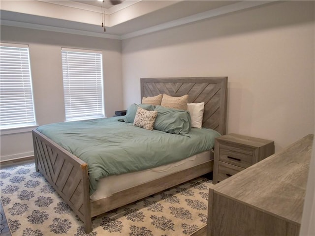 bedroom featuring crown molding, a tray ceiling, and hardwood / wood-style floors