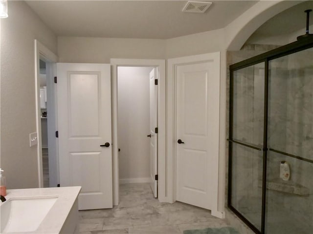 bathroom with vanity and a shower with shower door