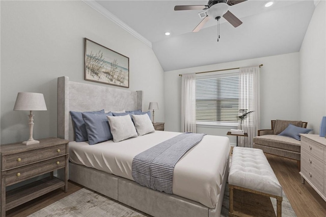 bedroom with lofted ceiling, hardwood / wood-style floors, ornamental molding, and ceiling fan