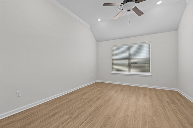 empty room featuring crown molding, ceiling fan, vaulted ceiling, and light wood-type flooring