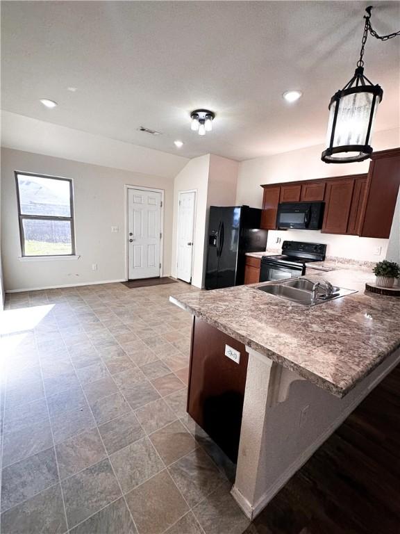 kitchen with pendant lighting, black appliances, a kitchen breakfast bar, and kitchen peninsula