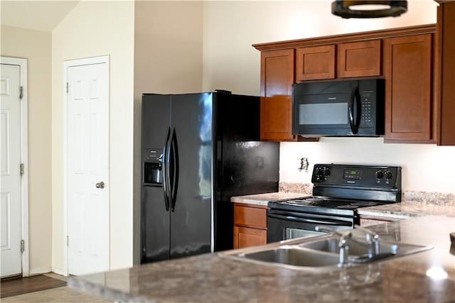 kitchen featuring vaulted ceiling, sink, and black appliances