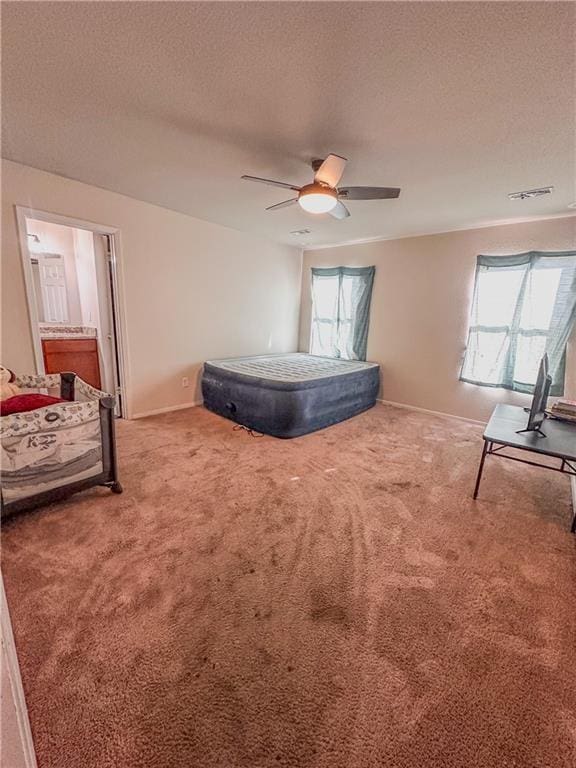 bedroom featuring multiple windows, carpet floors, a textured ceiling, and ceiling fan