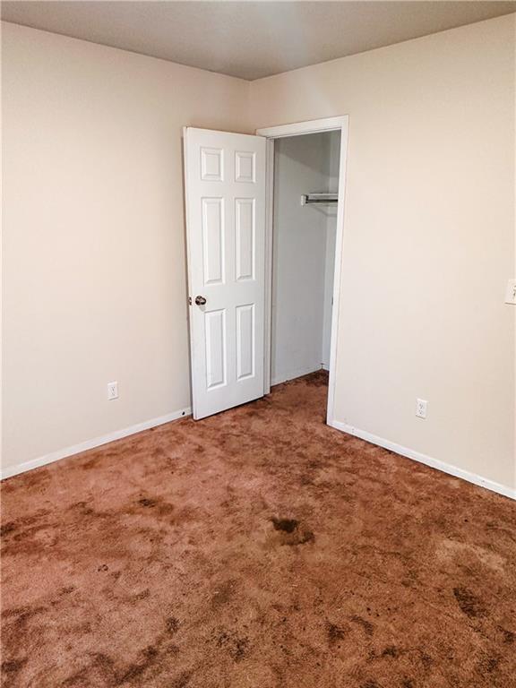 unfurnished bedroom with dark carpet