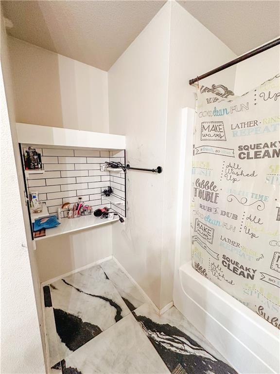 bathroom with bathing tub / shower combination