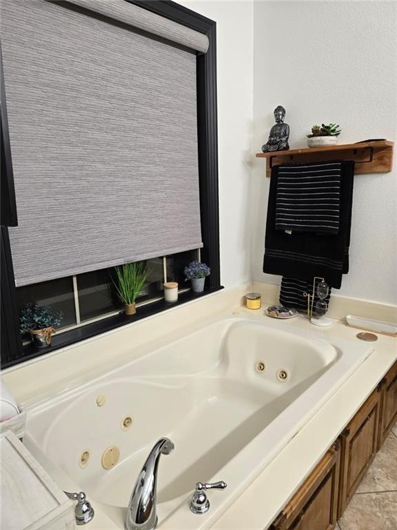 bathroom with tile patterned flooring and a washtub