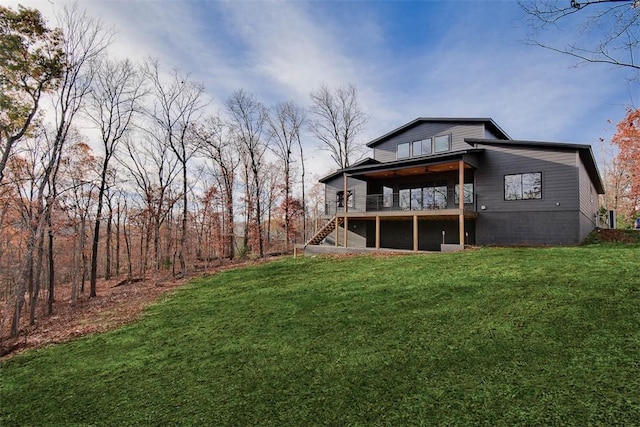 rear view of property with a yard and a deck