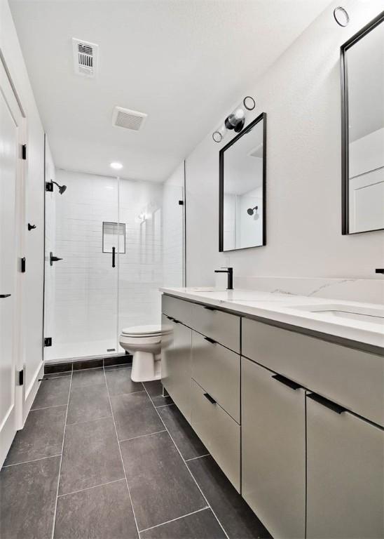 bathroom with walk in shower, tile patterned floors, vanity, and toilet