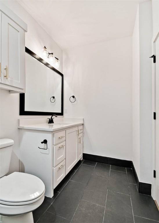 bathroom featuring vanity, tile patterned flooring, and toilet