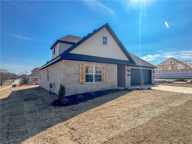 view of front of house with brick siding, an attached garage, and driveway