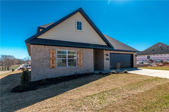 view of front of property featuring a front lawn, driveway, roof with shingles, an attached garage, and brick siding