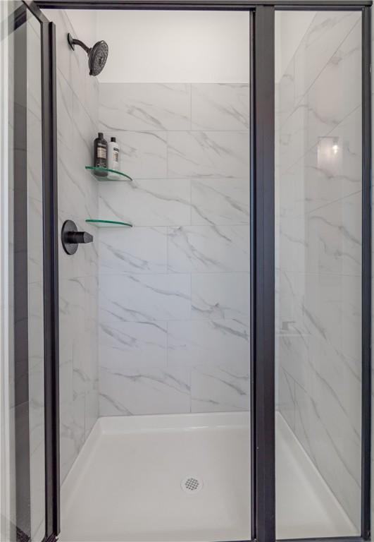 bathroom featuring a marble finish shower