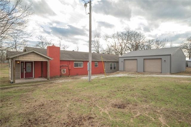 exterior space featuring a garage, an outdoor structure, and a front yard