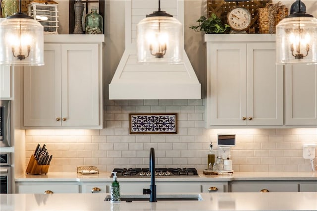 kitchen with tasteful backsplash, stainless steel appliances, custom exhaust hood, and white cabinets