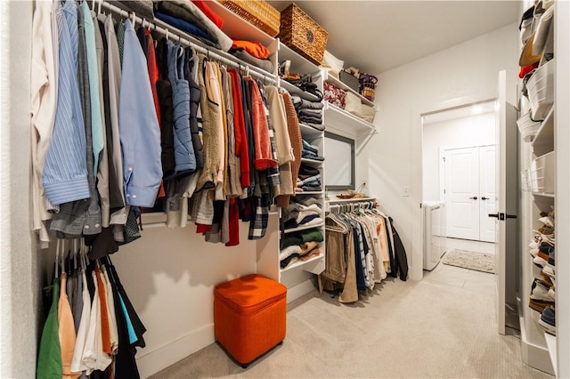 walk in closet featuring light carpet