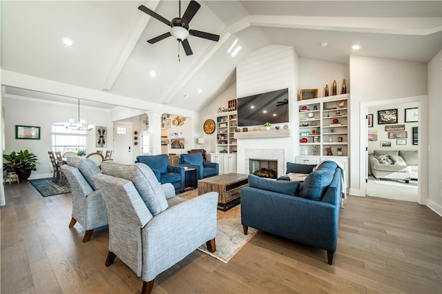 living room featuring ceiling fan with notable chandelier, high vaulted ceiling, decorative columns, beam ceiling, and light wood-type flooring