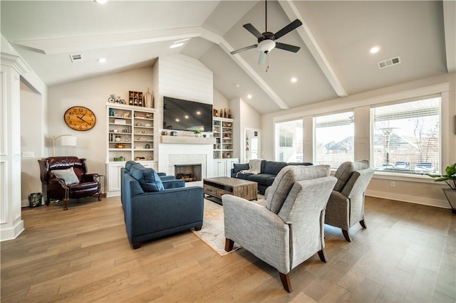 living room featuring lofted ceiling with beams, ceiling fan, and light wood-type flooring