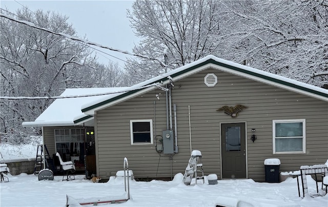 view of snow covered back of property