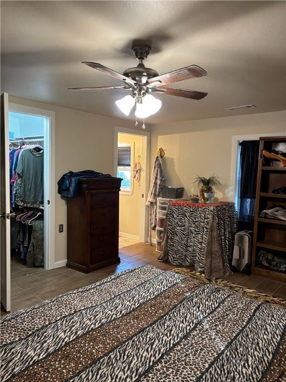 bedroom with ceiling fan, a closet, and a walk in closet