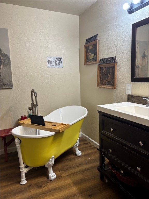 bathroom featuring hardwood / wood-style flooring, a bathing tub, and vanity