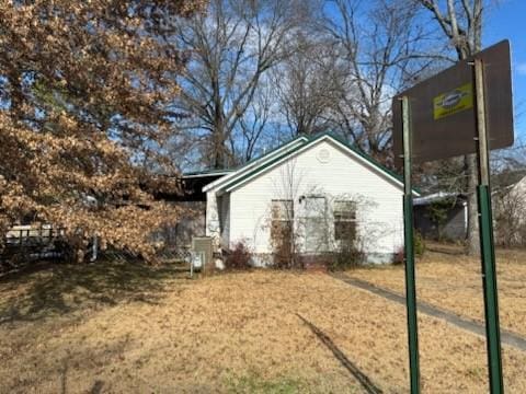 view of side of home with a yard